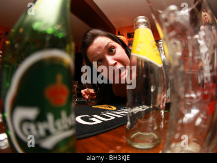 Drunk girl making faces in a bar. Stock Photo