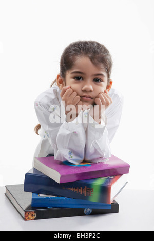 Girl leaning on a stack of books Stock Photo