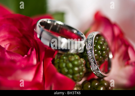 Wedding rings sitting on a bouquet of flowers. Stock Photo