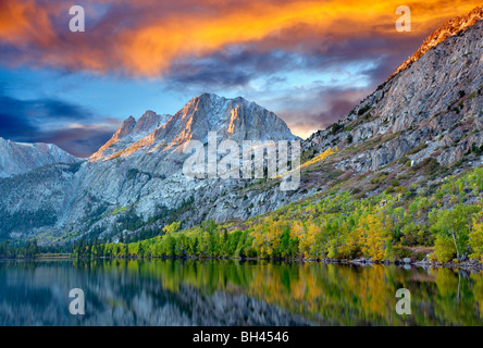 Silver Lake reflection with fall colored cottonwood trees and sunrise. California. Sky has been added. Stock Photo