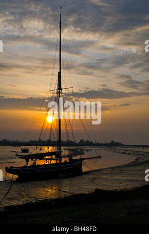 Oyster smack silhouetted against the early morning sun at Maldon. Stock Photo
