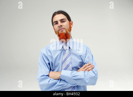 A young businessman with an orange beard wearing a blue shirt with a serious expression Stock Photo