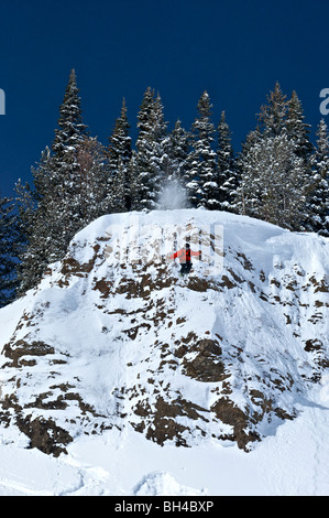 A man skiing off a cliff into a deep pillow of snow in Jackson Hole, Wyoming. Stock Photo