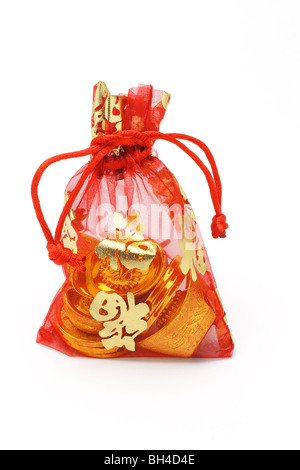 Chinese new year gold ingots and coins in red decorative sachet on white background Stock Photo
