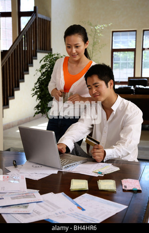 Chinese young couple chatting in front of a desktop at home Stock Photo