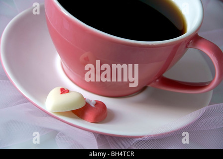 Pink coffee cup with chocolate hearts Stock Photo