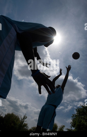 Basketball players are silhouetted in a blue UK