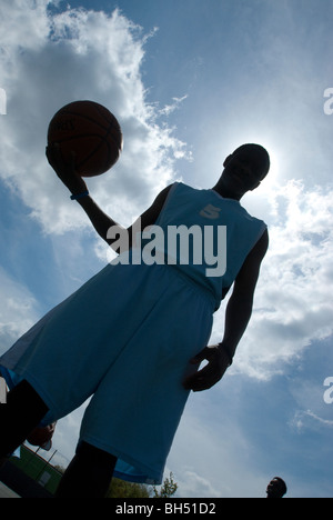 Basketball players are silhouetted in a blue UK