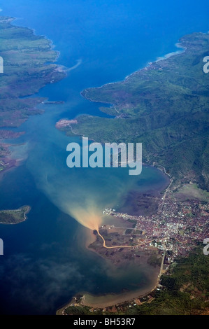 Aerial view of river running through town and spewing pollutants into the sea, Sumbawa, Indonesia Stock Photo