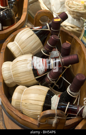 bottles of Valpolicella red wine wrapped in the classic raffia covering,  in wooden basket Stock Photo