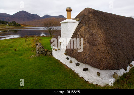 Traditional thatched crofting cottage at Luib, looking to the Red Cuillins, Isle of Skye. Stock Photo