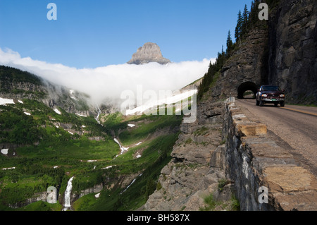 Cars emerge from the east side tunnel on the Going-to-the-Sun road, as Mt. Reynolds rises from Logan Pass in the background Stock Photo