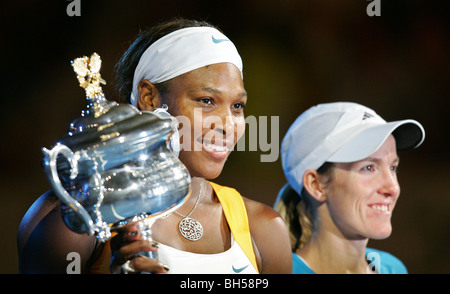 Serena Williams (L) poses with the trophy after winning her women's final match against Justine Henin. 2010 Australian Open Stock Photo