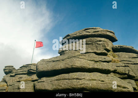 Red flag on Great Mis Tor on Dartmoor warning of live firing in progress, Devon UK Stock Photo