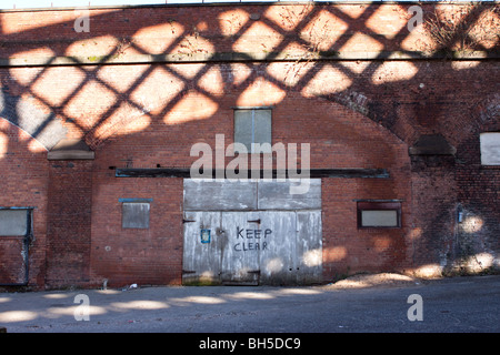Keep Clear sign on run-down wooden doors Stock Photo
