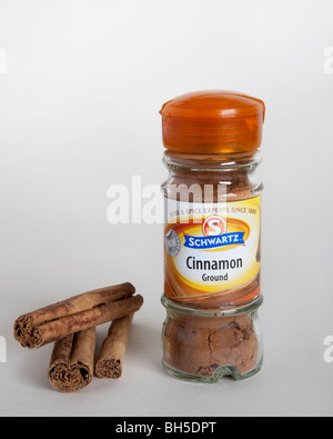 A jar of Schwartz ground cinnamon along with some cinnamon sticks. Stock Photo
