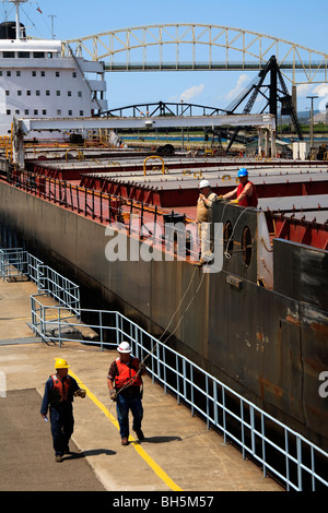Dock side workers taking the lines of a lake freighter passing through MacArthur Lock. Sault Ste. Marie, Michigan, USA Stock Photo