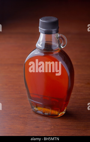 A bottle of maple syrup sits on a table Stock Photo