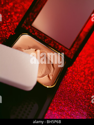 Foundation makeup with cotton applicator on red surface very colorful Stock Photo
