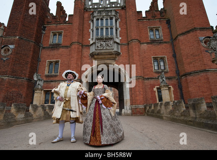 Two actors in Henry VIII and Ann Boleyn costumes posing outside the gate at Hampton Court Palace Stock Photo