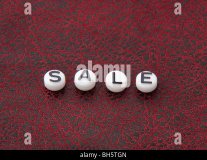 The word sale in red and black leather texture in this commerce series, great for backgrounds, buttons, icons, etc. Stock Photo