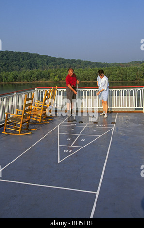 Senior citizens play shuffleboard on the deck of a paddlewheel steamboat cruise ship on the Mississippi River in Arkansas Stock Photo