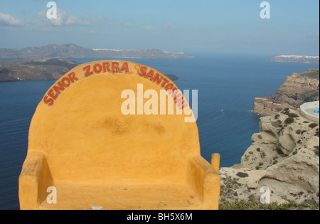 yellow bench with santorini sign with view  of the caldera and the sea Stock Photo