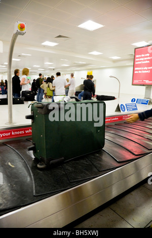 Single case / bag on the baggage / luggage reclaim carousel belt at – south terminal – Gatwick International airport. UK. Stock Photo