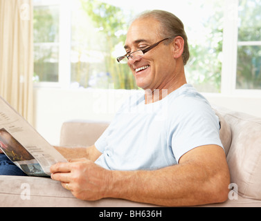 Senior Man Reading Newspaper At Home Stock Photo