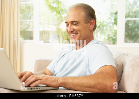 Senior Man Using Laptop At Home Stock Photo