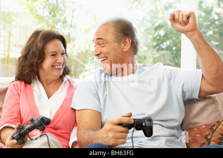Senior Couple Playing Computer Game At Home Stock Photo