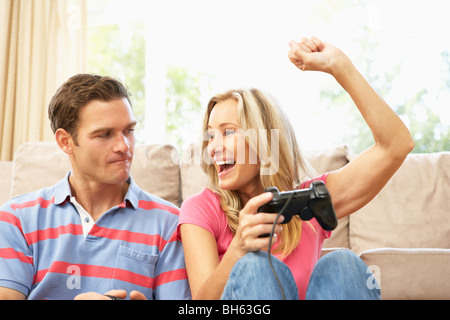 Young Couple Playing Computer Game On Sofa At Home Stock Photo