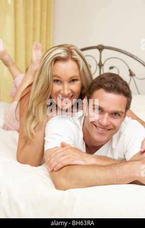 Couple Relaxing On Bed At Home Stock Photo