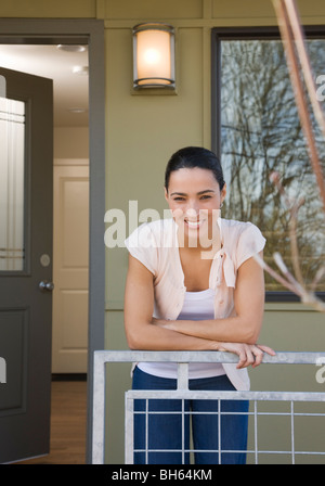woman on front porch with sold sign Stock Photo