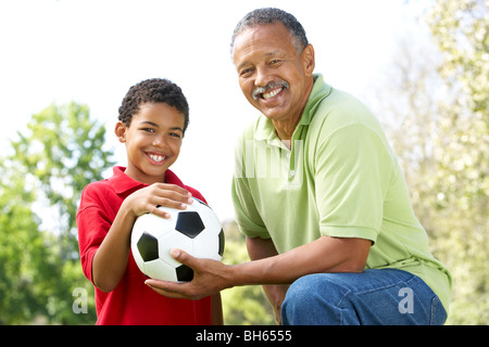 Grandfather With Grandson In Park With Football Stock Photo