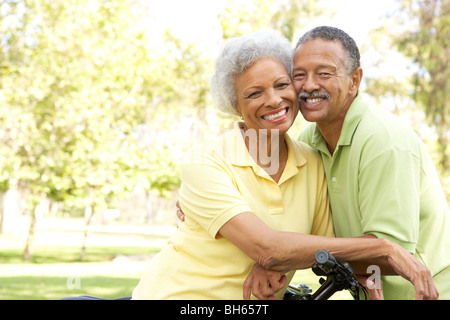 Senior Couple Riding Bikes In Park Stock Photo