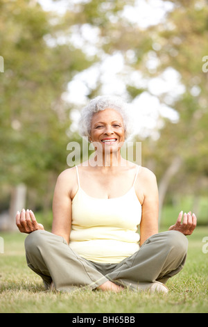 Senior Woman Doing Yoga In Park Stock Photo
