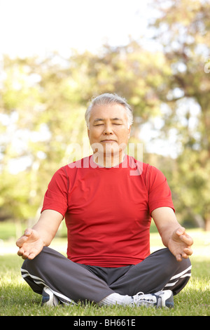 Senior Man Doing Yoga In Park Stock Photo