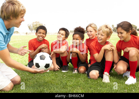 Young Boys And Girls In Football Team  With Coach Stock Photo