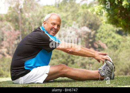 Senior Man Exercising In Park Stock Photo