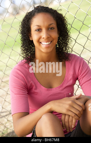 Teenage Girl Sitting In Playground Stock Photo