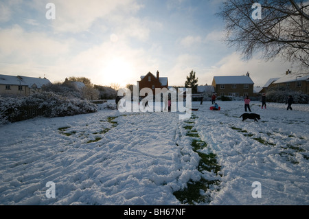 Children playing, building a snowman and having snowball fights in the snow Stock Photo