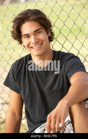 Teenage Boy Sitting In Playground Stock Photo