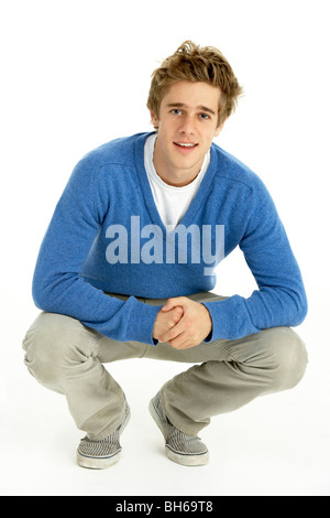 Young Man Crouching In Studio Stock Photo