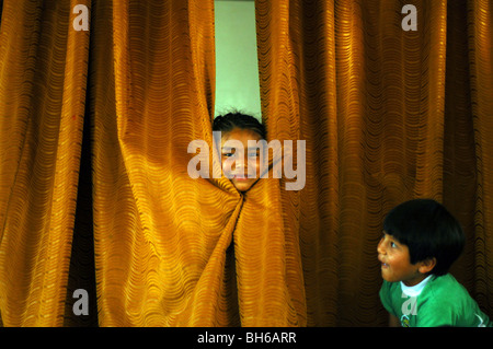 Ecuador, Yuarmachoa, a cheerful Ecuadorian girl hiding behind a curtain Stock Photo