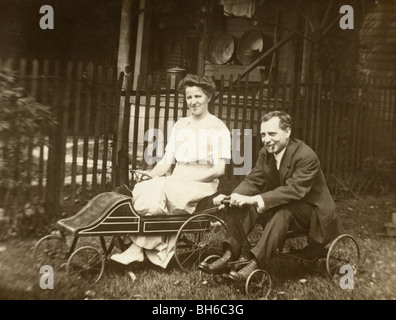 Adult Couple on Children's Pedal Cars Stock Photo