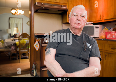 Elderly retired senior man sitting at home in his kitchen. Stock Photo