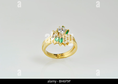 This is an emerald and diamond engagement ring set on a light background. Stock Photo