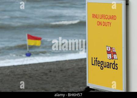 RNLI Lifeguards On Duty sign with safe bathing area flag, Aberystwyth, Wales. Stock Photo