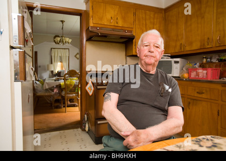 Elderly retired senior man sitting at home in his kitchen. Stock Photo